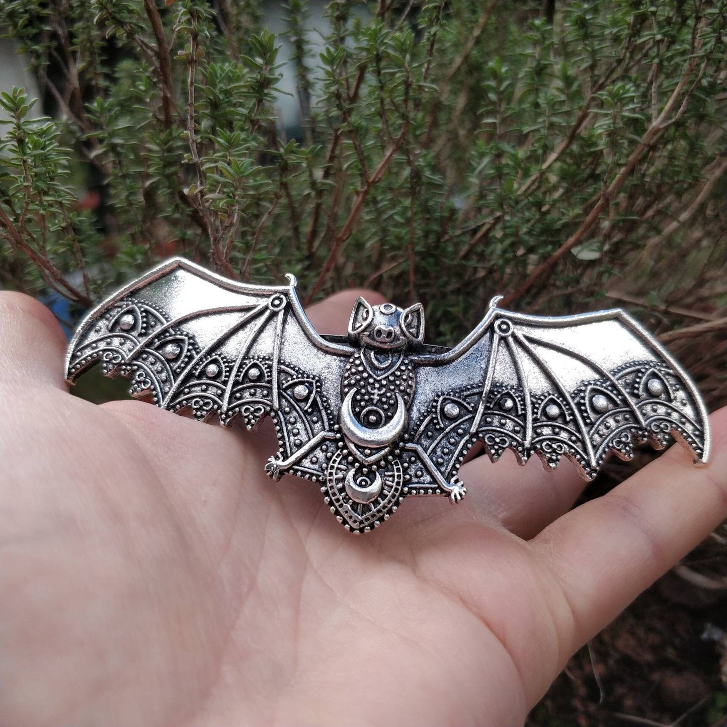 metal bat clip, smiling bat, textured metal with ornate patterns. esoteric and classic design