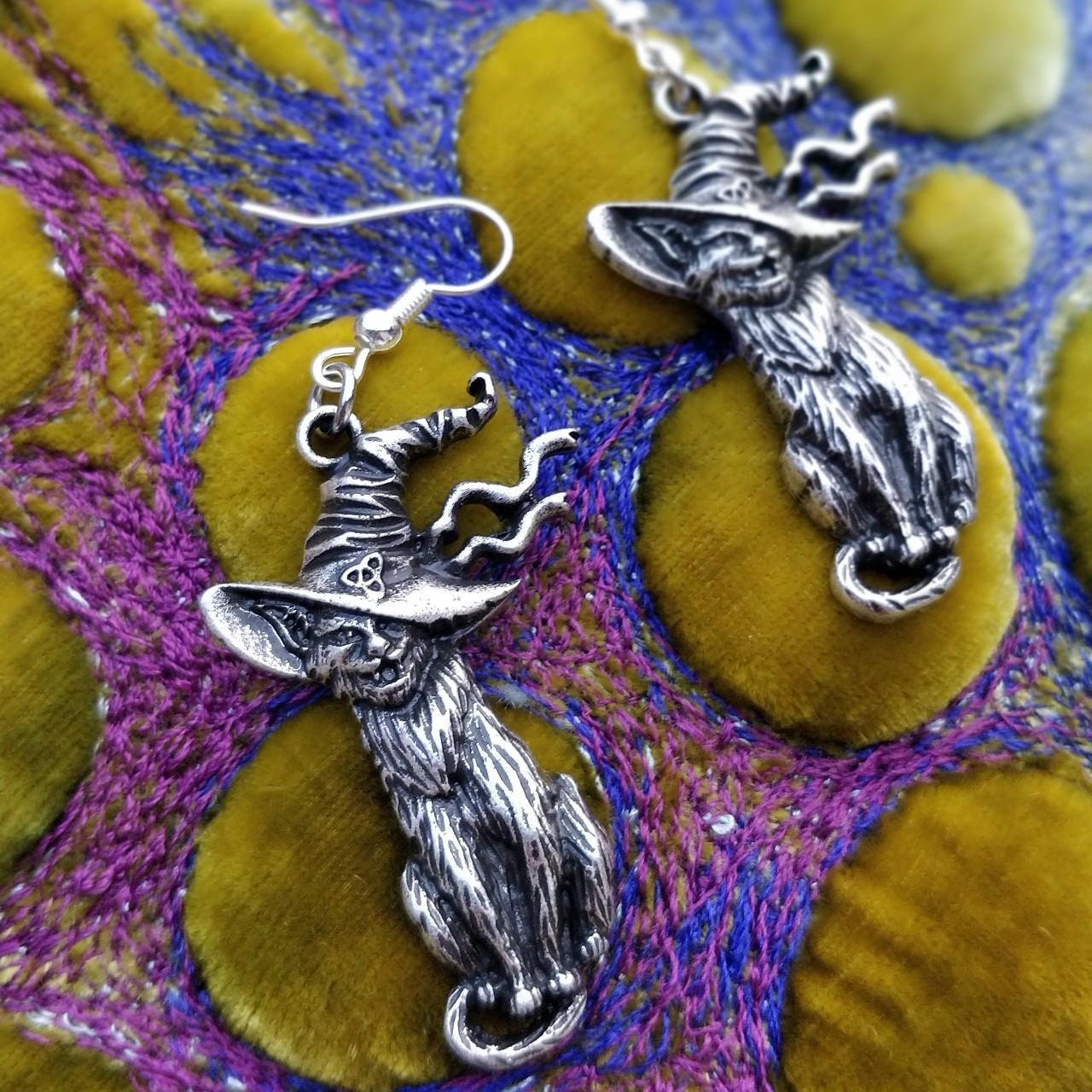mischievous cats with fangs showing, smiling in pagan witch hats